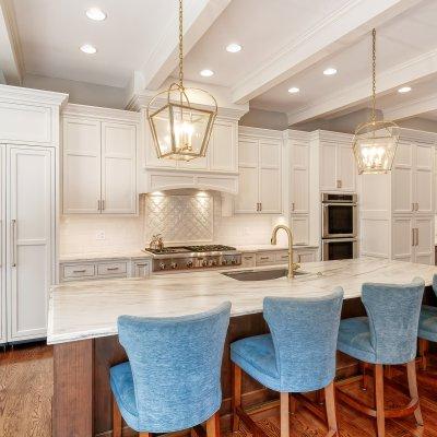 kitchen with white cabinets, white backsplash, and large island